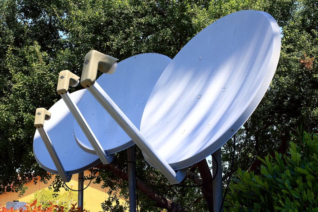 pexels-photo-17278622 Satellite dishes in nature setting, emphasizing technology blend with environment.